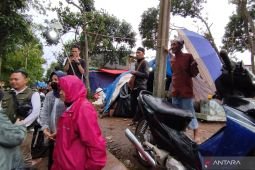 Risma menolak dipayungi saat hujan oleh pengungsi di Cianjur