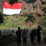 Upacara dan pengibaran bendera raksasa di Coban Putri